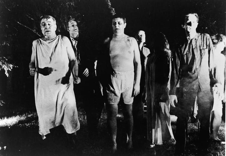 A black-and-white photo of walking ghouls from the movie 'Night of the Living Dead.'