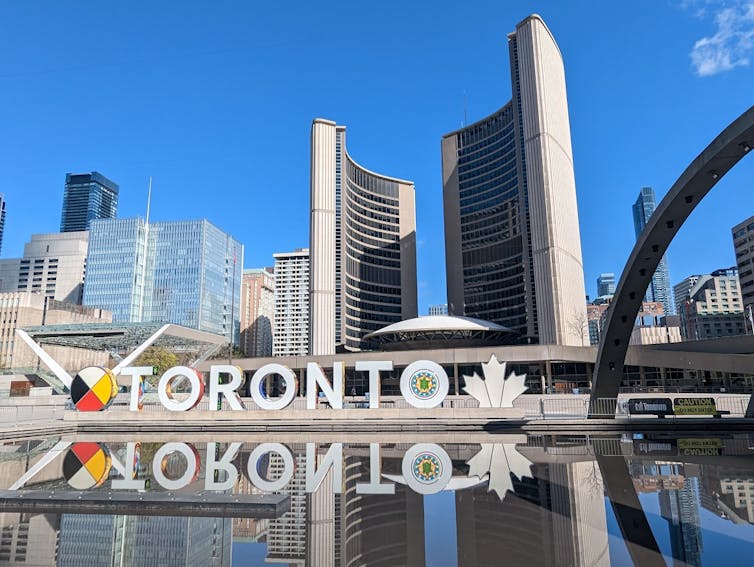 a sculpture spelling out TORONTO surrounded by tall buildings