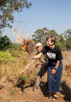 woman and man setting a small fire
