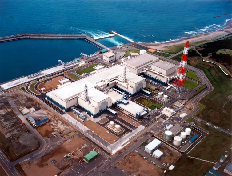 Aerial view of a power plant on the banks of the ocean.