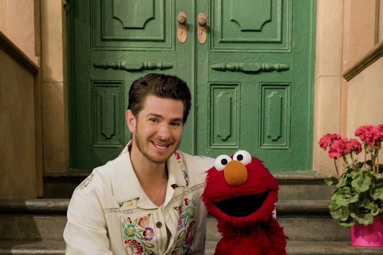 man sits on stairs with red children's puppet