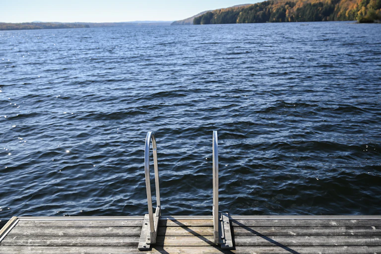 A lake and dock is seen with trees in the background.
