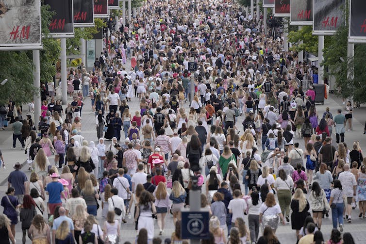 a crowd of people walking through an urban passageway