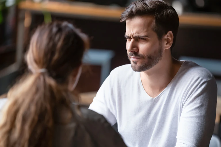 A man appears confused looking at a woman