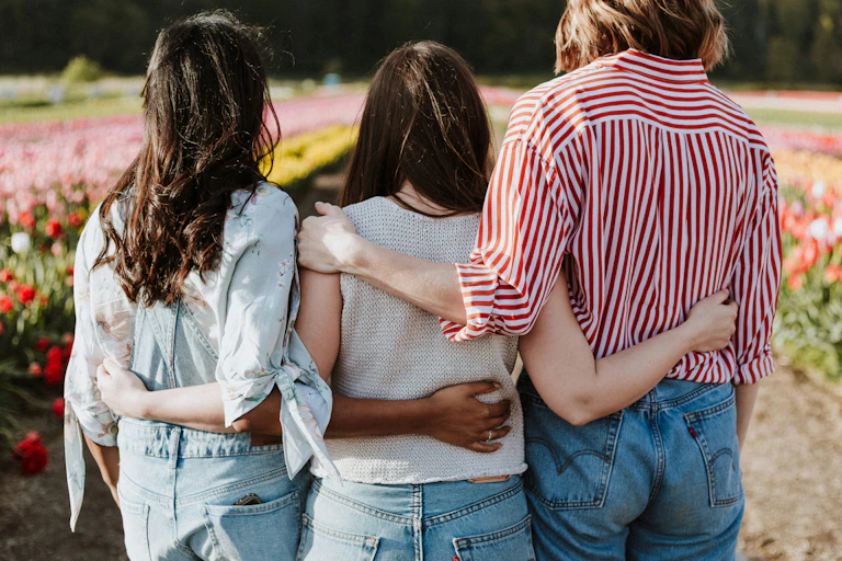 Three people in a supportive embrace