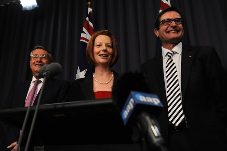The then-Treasurer Wayne Swan (left), then-Prime Minister Julia Gillard and then-climate change minister Greg Combet (right) laugh during a press conference in Canberra, Tuesday, Nov. 8, 2011. The carbon tax legislation was passed by the Senate that day.