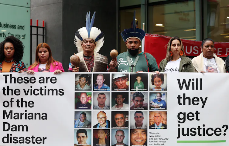 Group of people holding a large banner outside a building