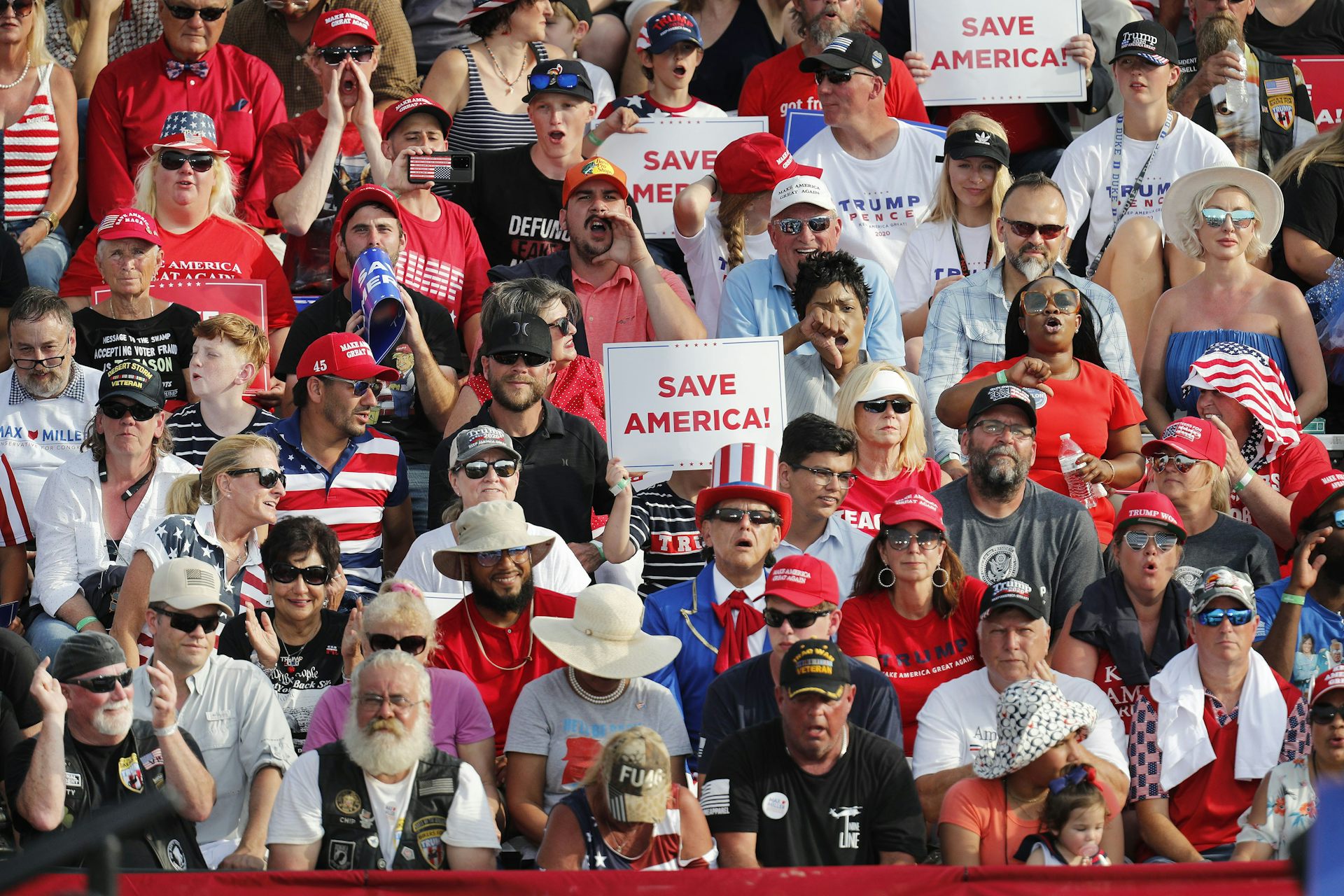 Supporters of Donald Triump hold up signs saying 'Save America' at a rally in Ohio, 2021.