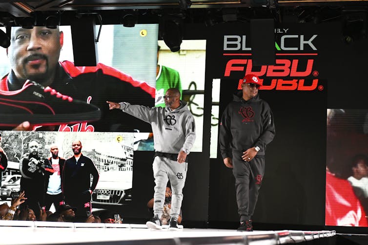 Black entrepreneurs appear on stage to greet a crowd.