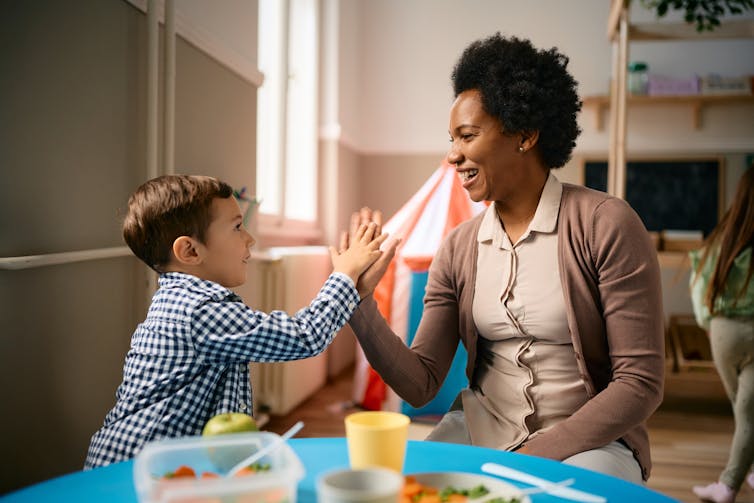 Child and teacher high fiving