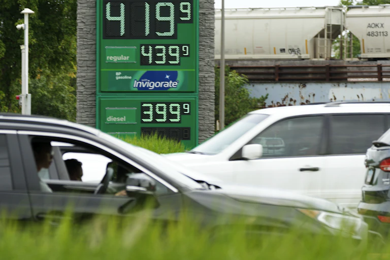 Cars outside a gas station showing $4.19 per gallon.