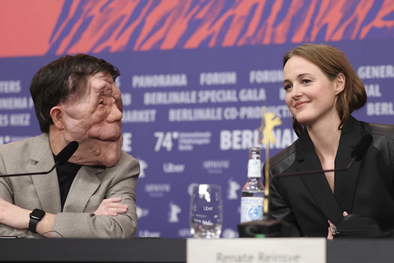 Two people sitting in dialogue at a press conference.