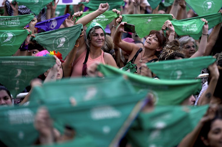 Women cheer holding green bananas