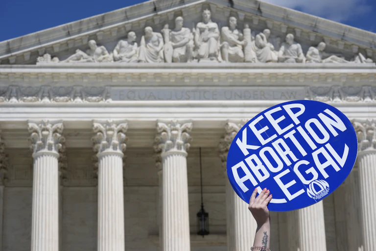 A person holds up a sign as abortion-rights activists and Women's March leaders protest as part of a national day of strike actions outside the Supreme Court