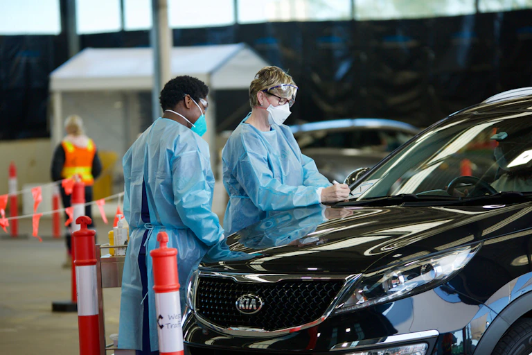 Health workers wearing masks and gowns at drive through COVID testing