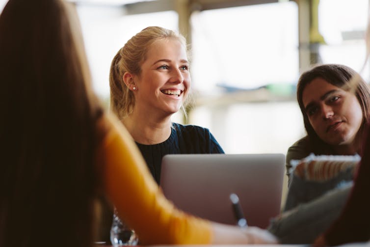 Two female students sit in a classroom, looking like they are listening to what is happening.