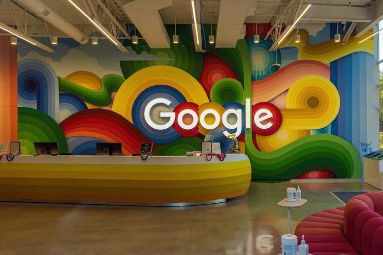 Google logo behind a desk in a colourful foyer.