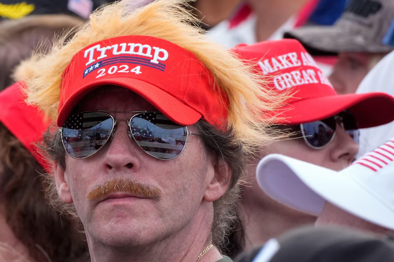 A Trump supporter wears a hat saying Trump 2024.
