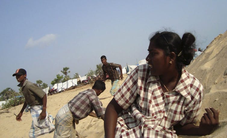 People duck for cover in a sandy area