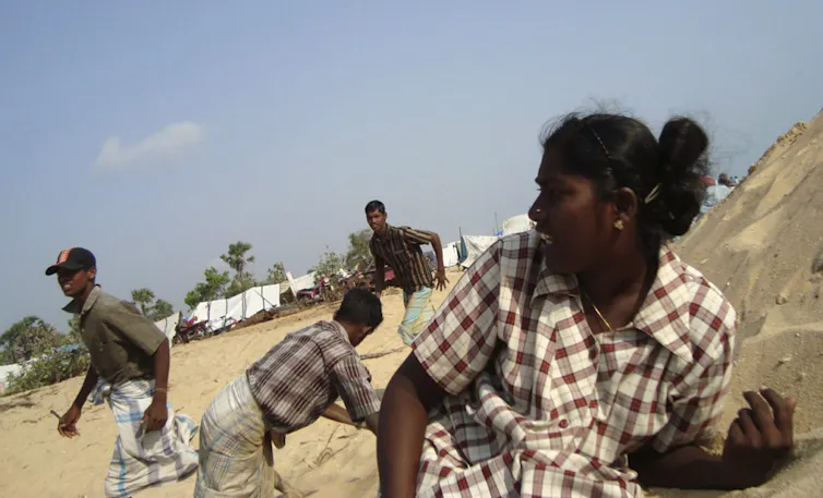 People duck for cover in a sandy area