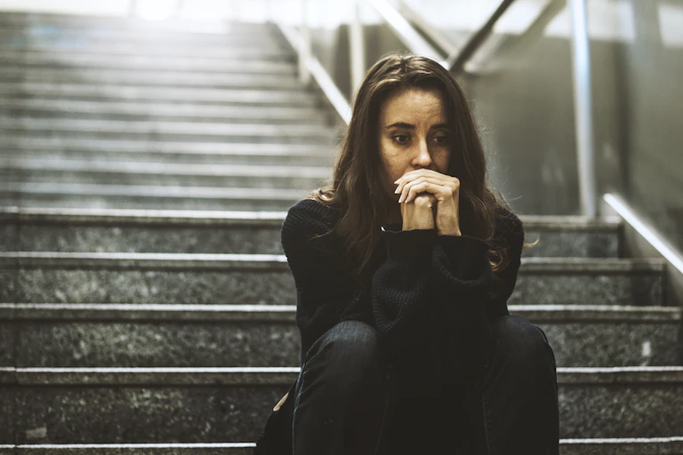 woman sitting looking worried on the stairway