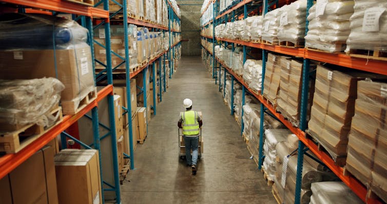 Man pushing trolley in a warehouse