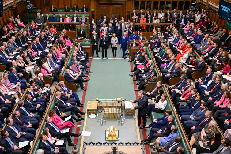An aerial view of the House of Commons chamber, full of MPs.