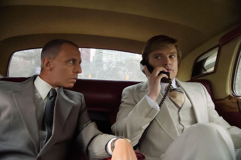 Two businessmen in suits in the back of a NY taxi cab.