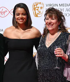 A young black woman and an older white woman dressed in evening wear at an awards ceremony.