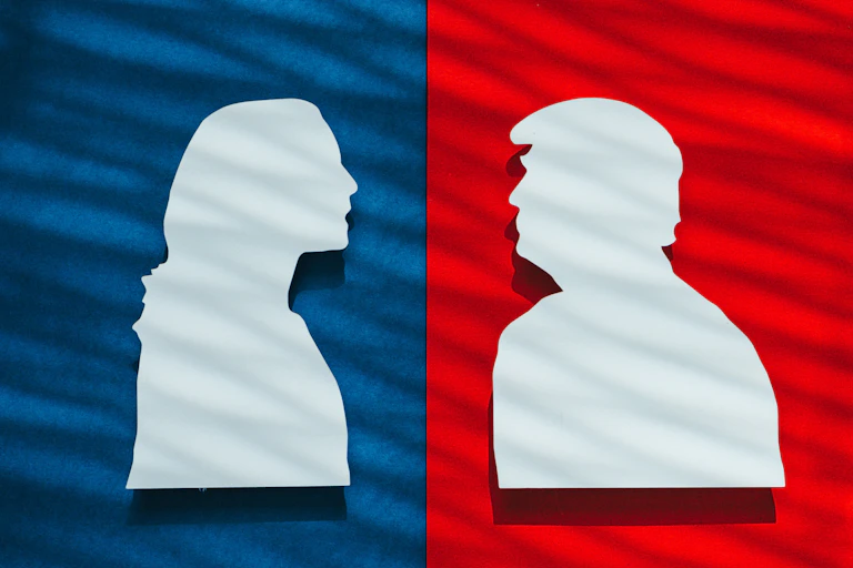 Silhouettes of Harris and Trump facing one another.