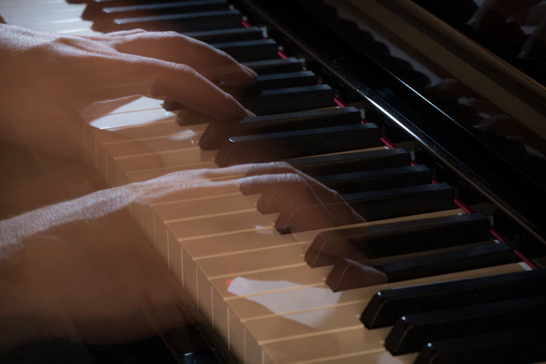 See-through, ghostly hands play a piano.