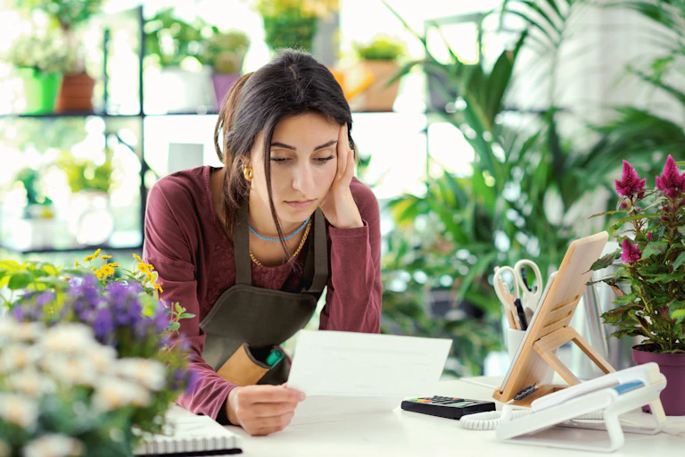 worried florist looking at a bill