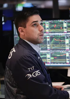 A trader sits at a computer at the New York Stock Exchange