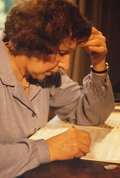 A woman, who claims to be able to channel the spirits of classical composers, writing music.