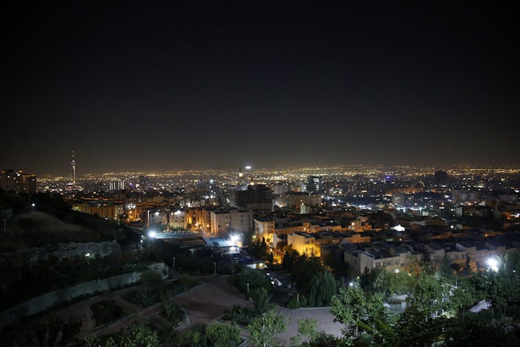 the skyline of a city is seen illuminated at night.