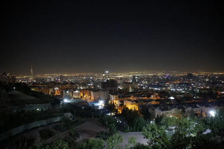 the skyline of a city is seen illuminated at night.