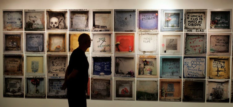 Gin Lane by way of William Hogarth is a critique of 18th-century London’s rising funeral industry 4 A man looks at Requiem NN, a large photography wall.