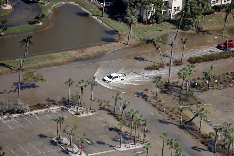 Una vista aérea de un automóvil que conduce a través de una calle inundada