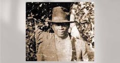 A black and white photograph of a Black man was lynched by white supremacist in Florida on Election Day in 1920.