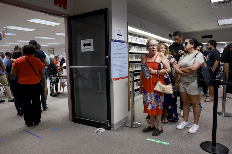 A messy line of people moves from the right side of the photo to the left.