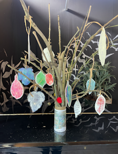 twigs in a pot with crafted coloured leaves, kids art/climate project