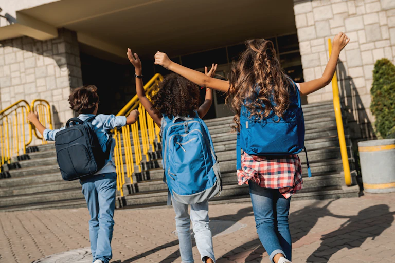 Happy children going into school