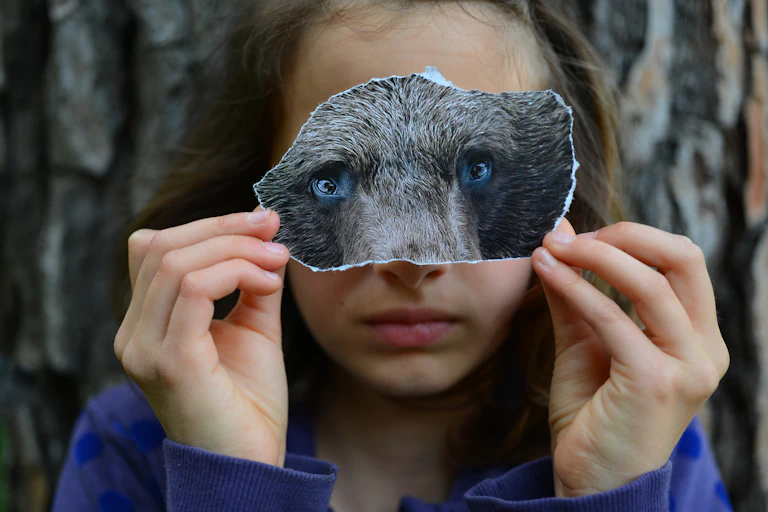 Young girl playing with a bear mask