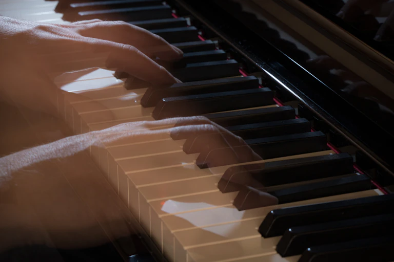 Mãos transparentes e fantasmagóricas tocam um piano.