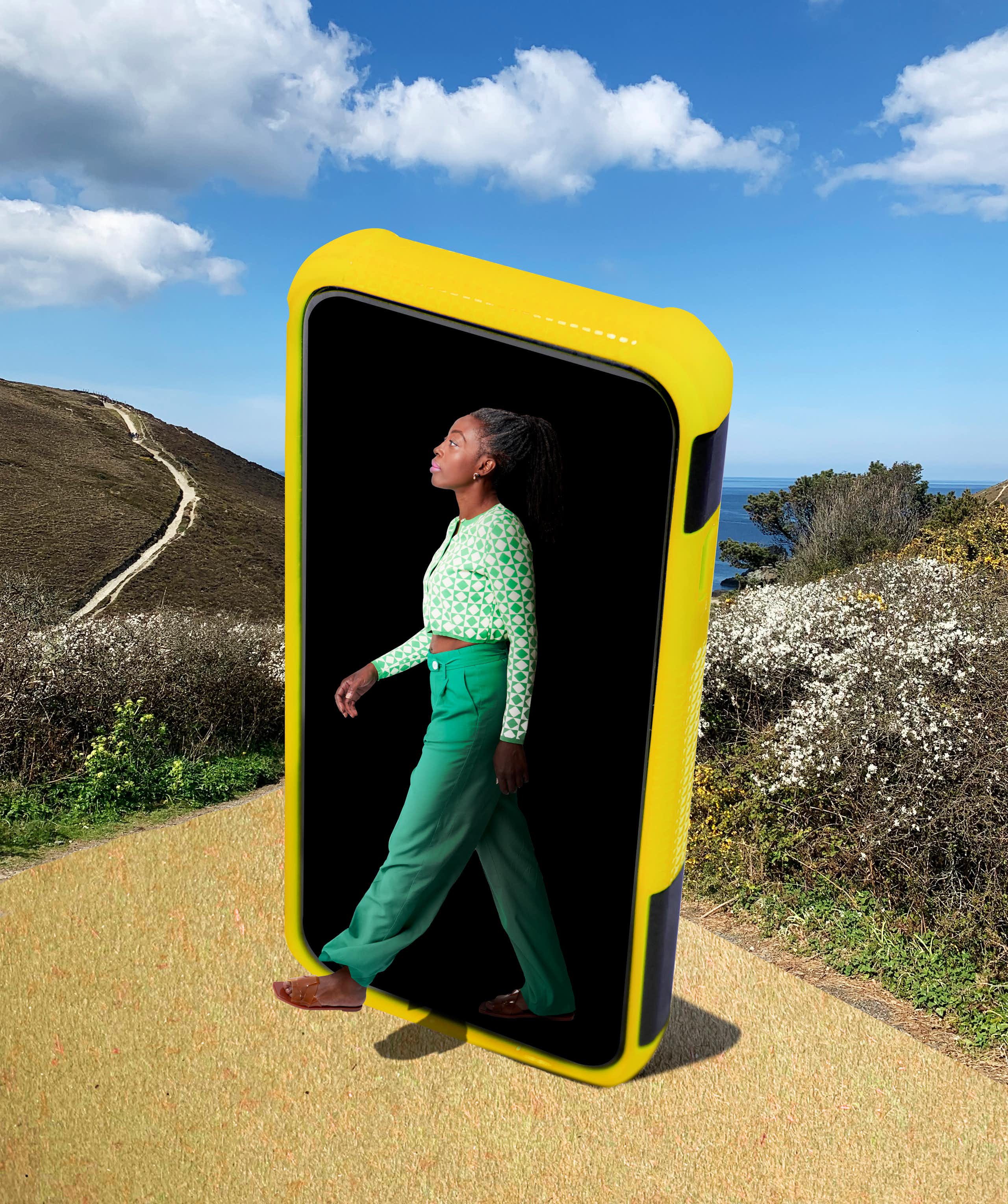 a woman appears to emerge from a giant smartphone onto a path in a nature preserve