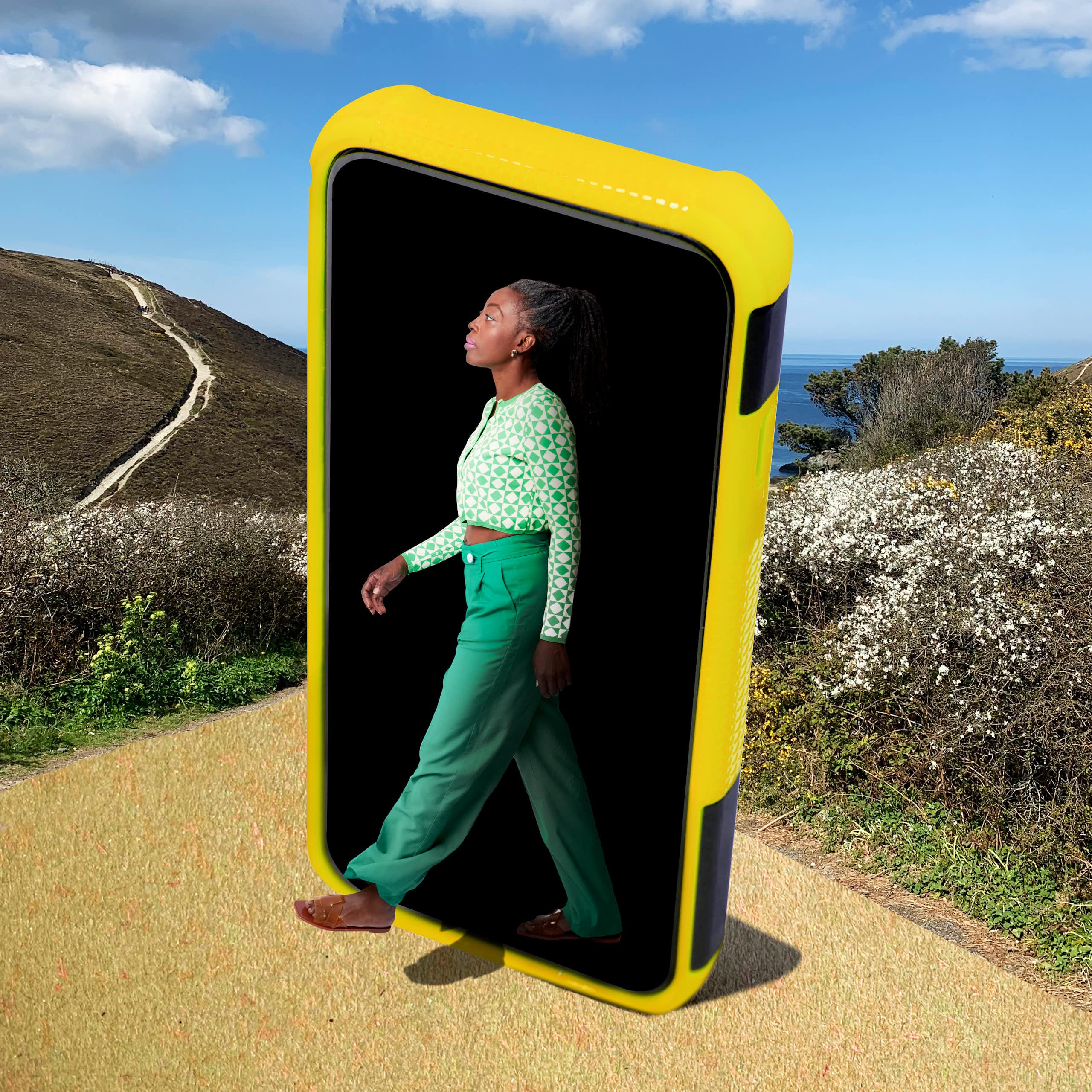 a woman appears to emerge from a giant smartphone onto a path in a nature preserve