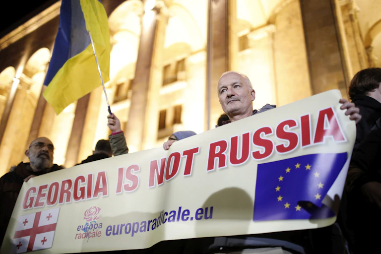 Protesters in front of the Georgian parliament building in Tblisis holding up a sign reading: Georgia is not Russia.