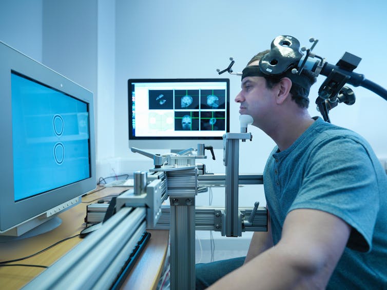 A man receives transcranial magnetic stimulation in a lab.