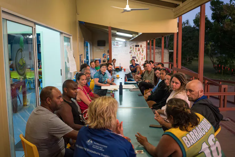 People talk together at a consultation around a table.