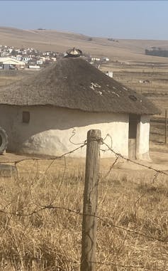 A circular building with a thatched roof.